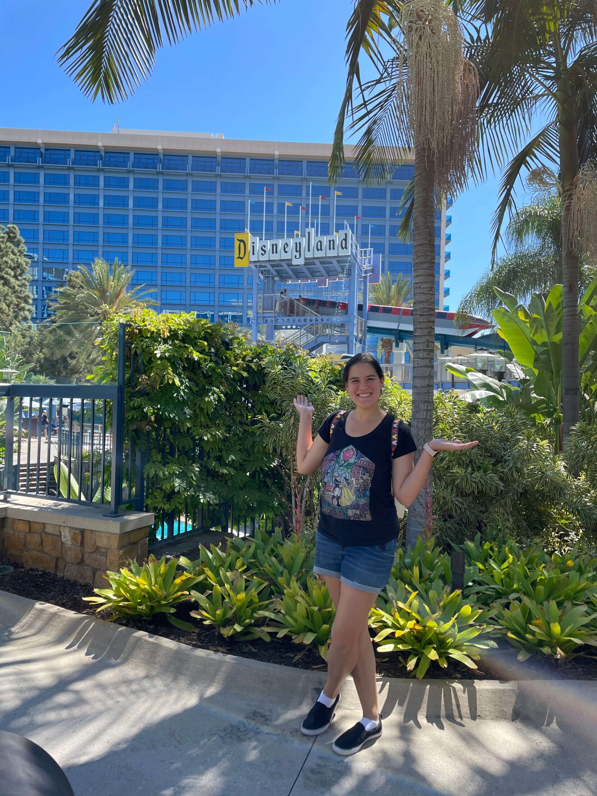 me standing among landscaping in front of the disneyland hotel sign